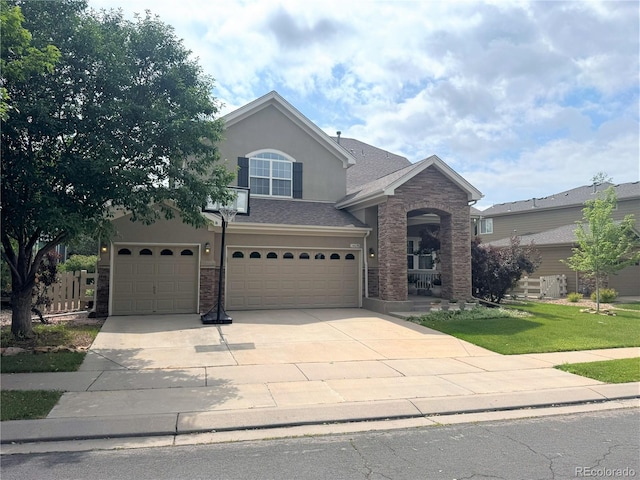 14096 Roaring Fork Cir, Broomfield, CO 80023 - traditional home featuring driveway, a garage, stucco siding, a front yard, and brick siding