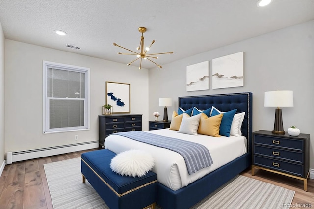 bedroom with a baseboard heating unit, recessed lighting, a chandelier, wood finished floors, and baseboards