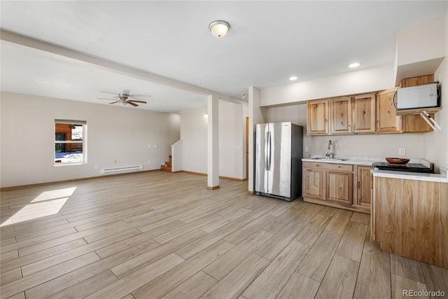 5844 Middle Fork Vis, Fairplay, CO 80440 - kitchen featuring freestanding refrigerator, a baseboard radiator, light countertops, white microwave, and light wood-style floors