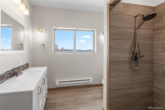 5844 Middle Fork Vis, Fairplay, CO 80440 - bathroom featuring a baseboard heating unit, vanity, tiled shower, and wood finished floors