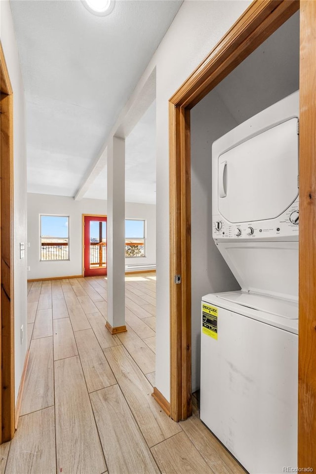 5844 Middle Fork Vis, Fairplay, CO 80440 - laundry area featuring stacked washer / dryer, plenty of natural light, and light wood-style flooring