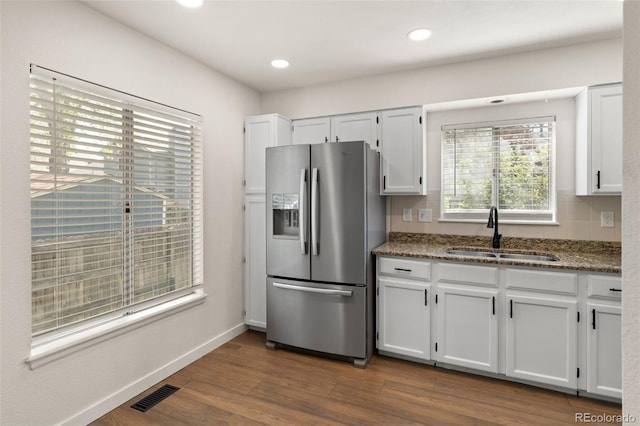 kitchen featuring stainless steel fridge with ice dispenser, a sink, stone countertops, white cabinets, and dark wood-style floors