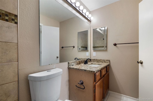 bathroom with toilet, vanity, and tile patterned flooring