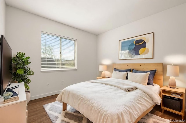 bedroom featuring wood finished floors and baseboards