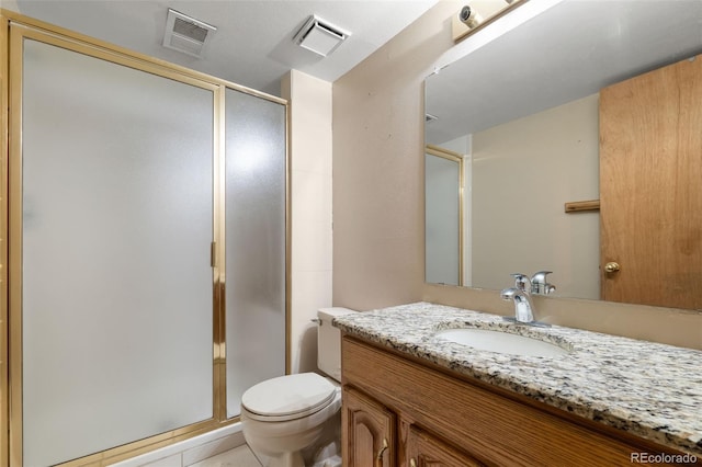 bathroom featuring a shower stall, toilet, vanity, and tile patterned floors