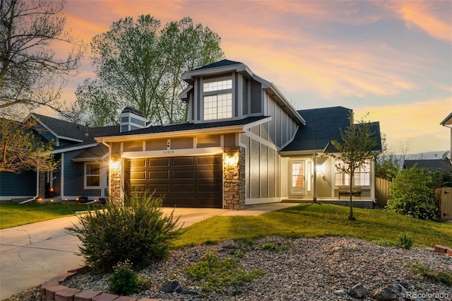 view of front of house featuring board and batten siding, driveway, stone siding, and a garage