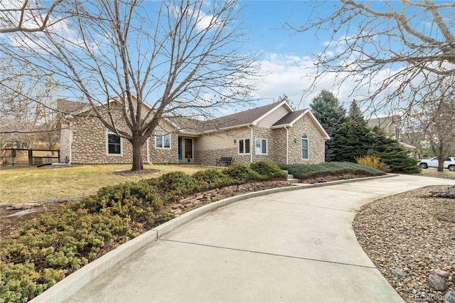 view of front of home featuring stone siding and a front lawn