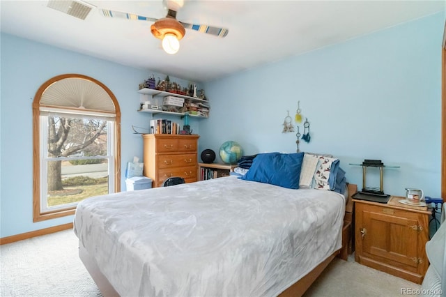 bedroom featuring baseboards, light colored carpet, and ceiling fan