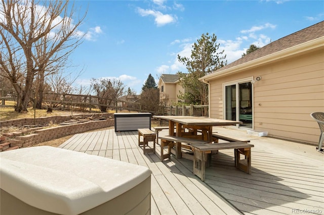 deck featuring outdoor dining space and a hot tub