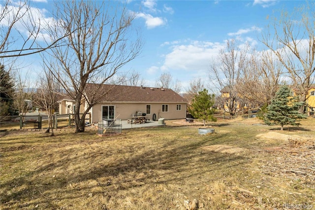 back of property with a yard, a patio, and fence