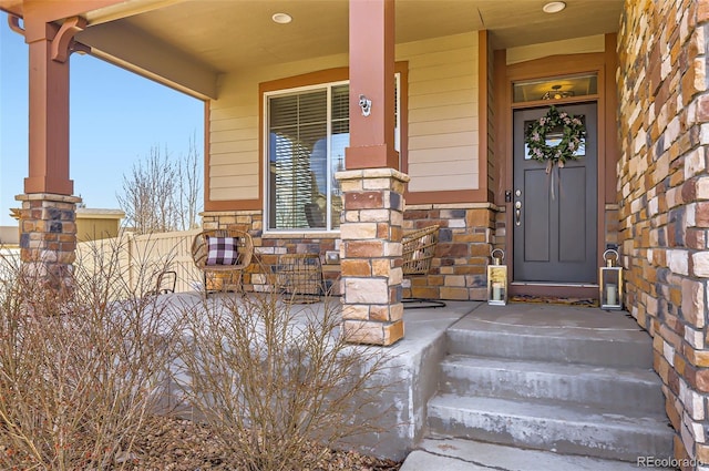 property entrance with stone siding and fence