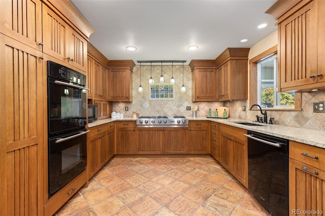 kitchen with light stone countertops, sink, black appliances, and decorative backsplash