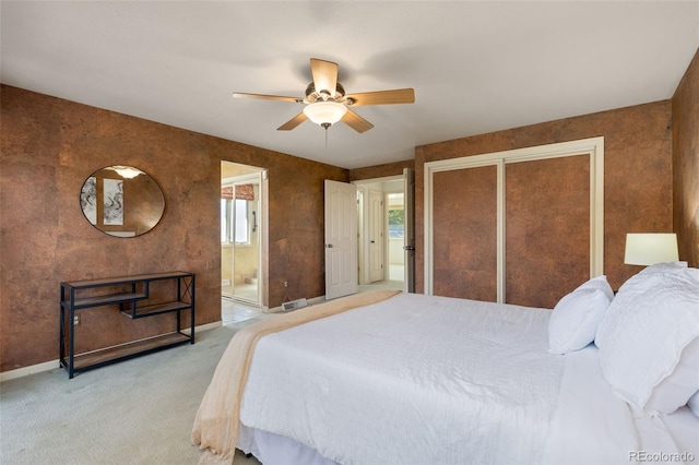 carpeted bedroom featuring a closet, connected bathroom, and ceiling fan