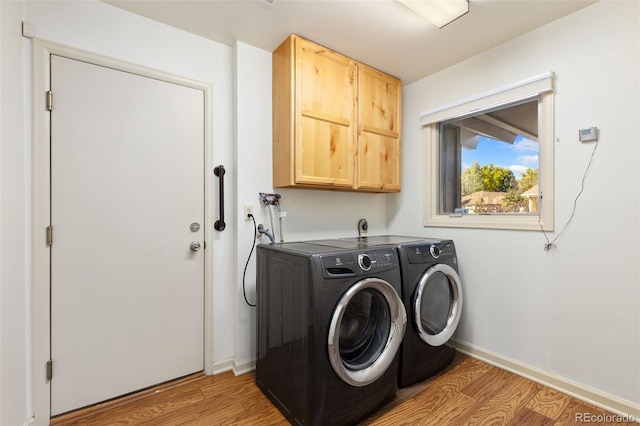 laundry area featuring light hardwood / wood-style floors, cabinets, and independent washer and dryer