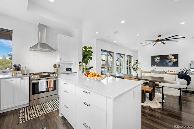 kitchen with recessed lighting, wall chimney exhaust hood, and gas range