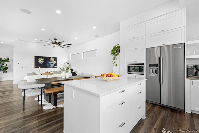 kitchen with dark wood-type flooring, white cabinetry, a center island, and stainless steel appliances