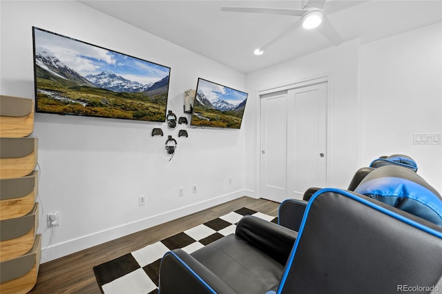 living area featuring baseboards, a ceiling fan, and wood finished floors