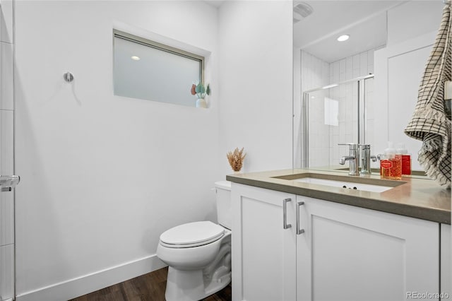 full bathroom with vanity, toilet, baseboards, a shower stall, and wood finished floors