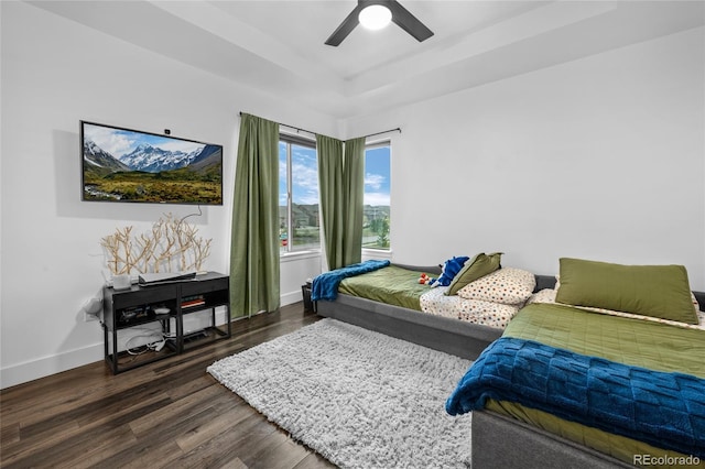 bedroom with baseboards, dark wood finished floors, ceiling fan, and a raised ceiling