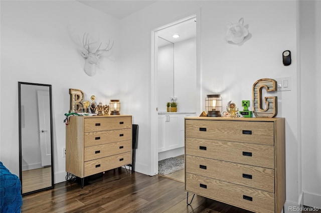 bedroom with baseboards and dark wood-type flooring