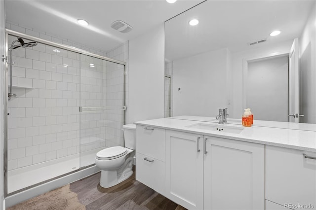 full bath with vanity, visible vents, wood finished floors, toilet, and a shower stall