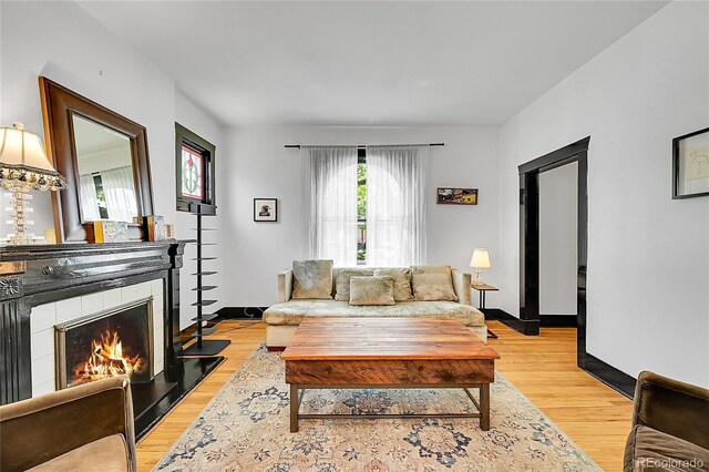 444 S Pearl St, Denver, CO 80209 - living room featuring a warm lit fireplace and light wood-type flooring