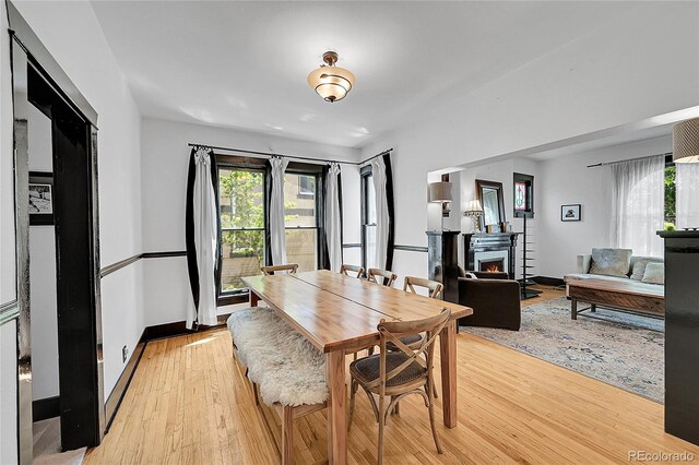 444 S Pearl St, Denver, CO 80209 - dining room with healthy amount of natural light, light wood-style flooring, and a warm lit fireplace