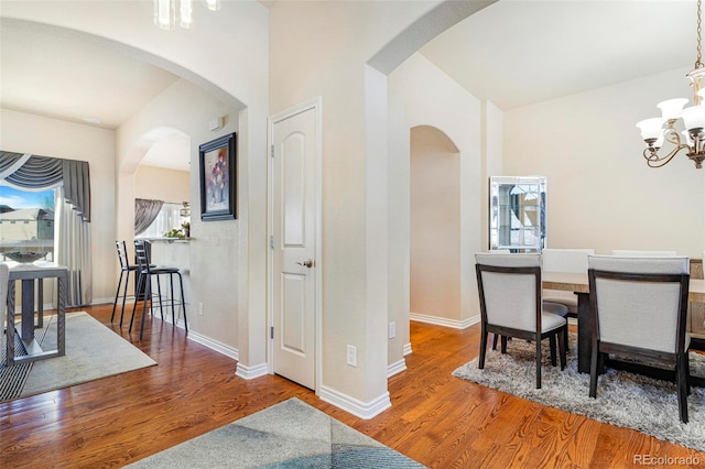 dining space featuring a notable chandelier, baseboards, and wood finished floors