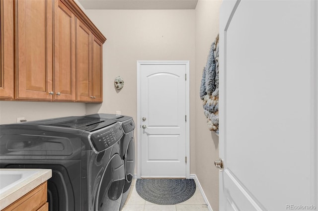 laundry room featuring cabinet space, light tile patterned floors, baseboards, and separate washer and dryer