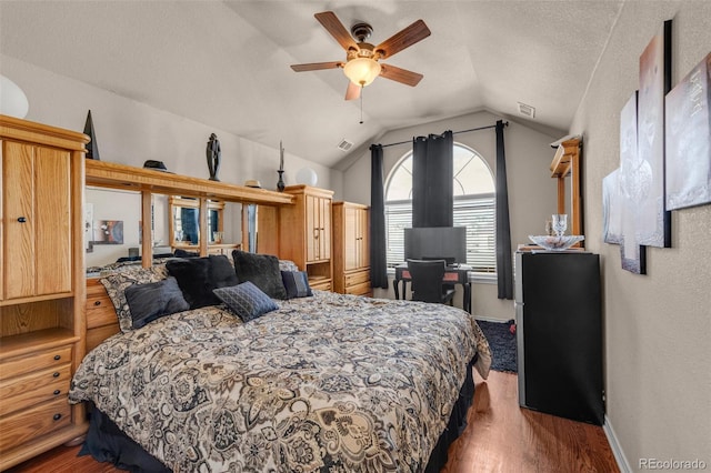 bedroom with dark wood-style floors, lofted ceiling, visible vents, and baseboards