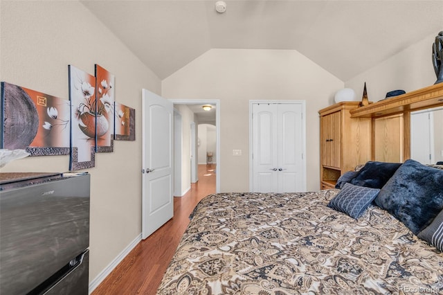 bedroom featuring lofted ceiling, baseboards, and dark wood-style flooring