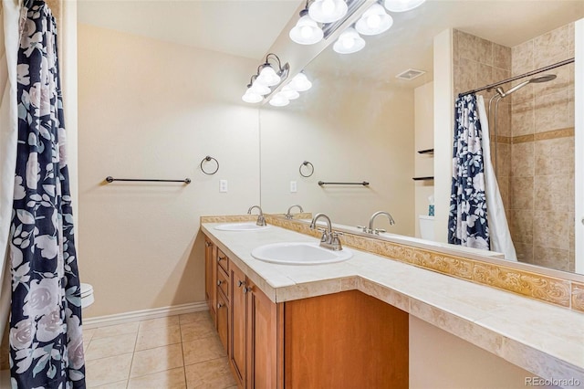 bathroom with double vanity, visible vents, a sink, and tile patterned floors