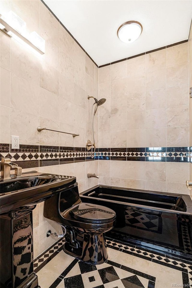 bathroom featuring tile walls and toilet