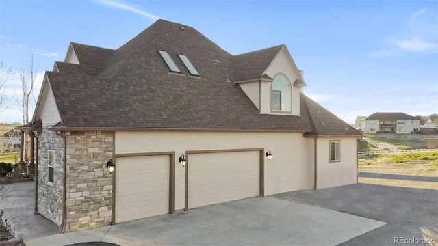 view of property exterior with driveway, stone siding, a shingled roof, and an attached garage