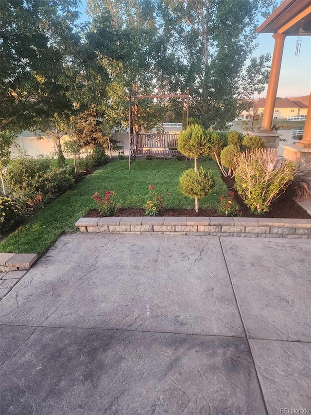 yard at dusk featuring a patio