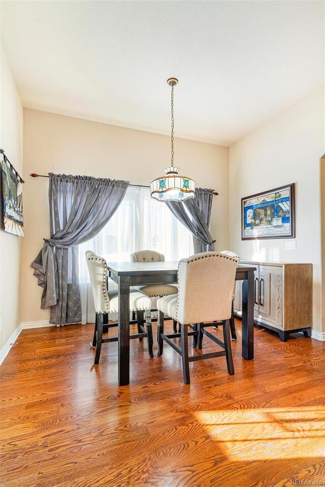 dining space featuring baseboards and wood finished floors