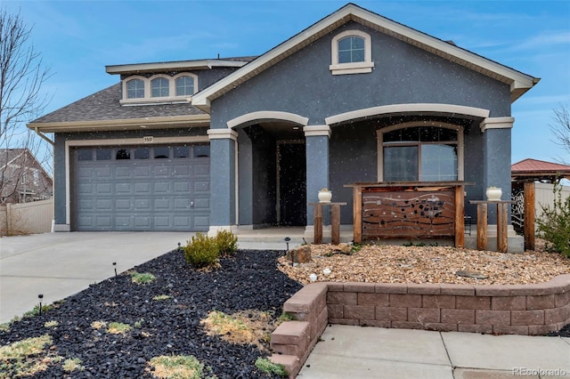 5519 Genoa St, Denver, CO 80249 - view of front of home featuring stucco siding, driveway, a garage, roof with shingles, and covered porch
