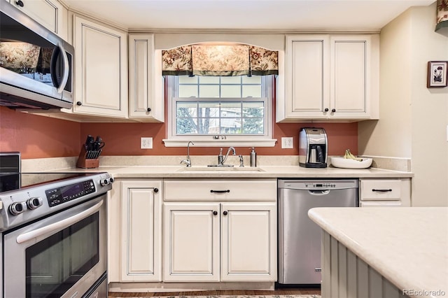 kitchen with light countertops, a sink, white cabinets, and stainless steel appliances