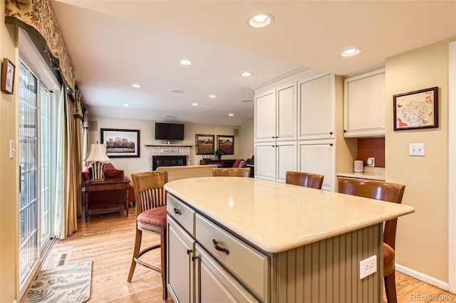 kitchen with white cabinetry, plenty of natural light, light wood-style flooring, and a center island