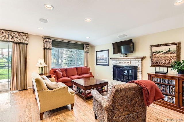 living room with plenty of natural light, wood finished floors, and a fireplace