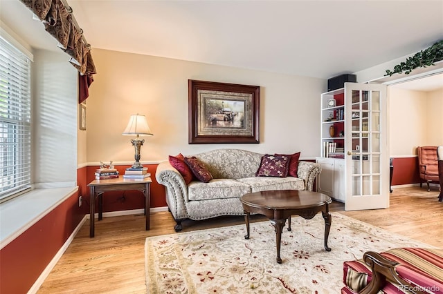 living room with baseboards, wood finished floors, and french doors