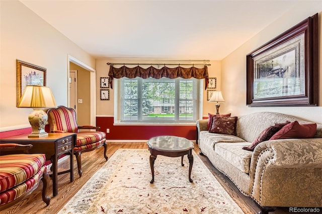 living area with baseboards and wood finished floors