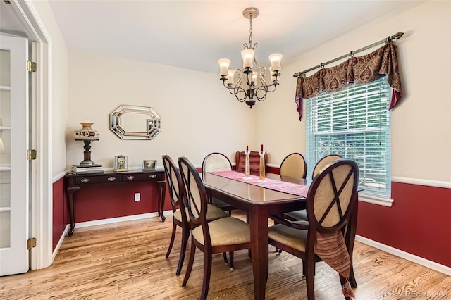 dining space with a healthy amount of sunlight, baseboards, light wood-type flooring, and a chandelier