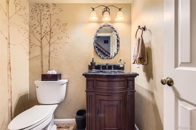 bathroom with toilet, baseboards, wood finished floors, and vanity