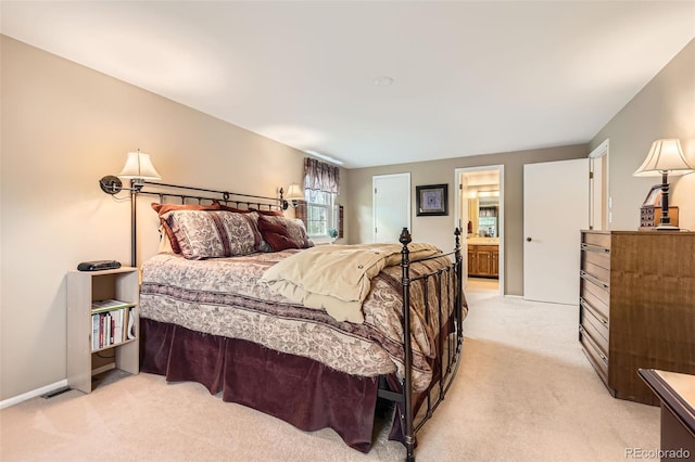 bedroom featuring light colored carpet, baseboards, and ensuite bathroom