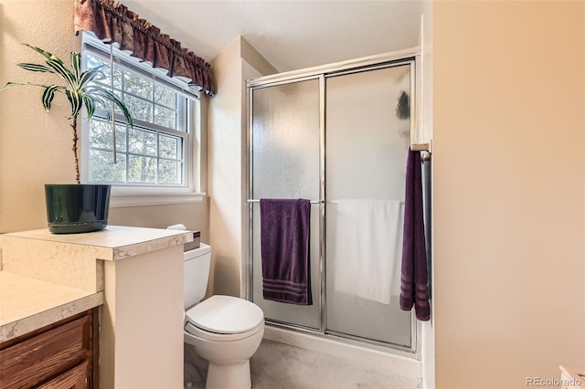 full bath with vanity, toilet, and a stall shower