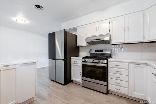 kitchen featuring light hardwood / wood-style flooring, backsplash, appliances with stainless steel finishes, and white cabinets