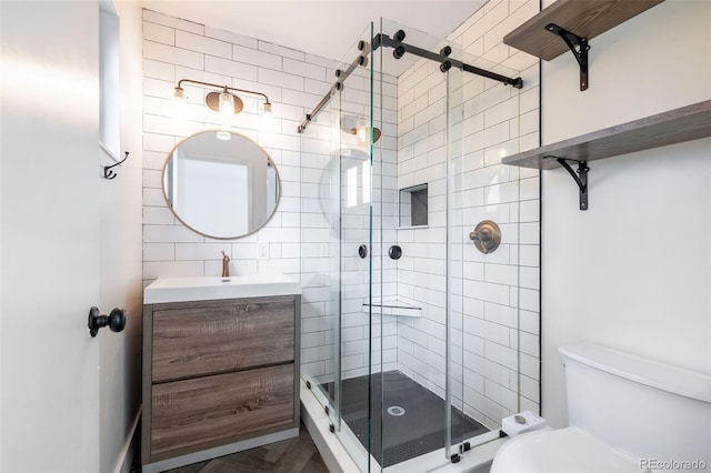 bathroom with an enclosed shower, vanity, and toilet