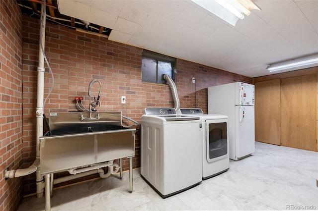 washroom with washer and clothes dryer and brick wall