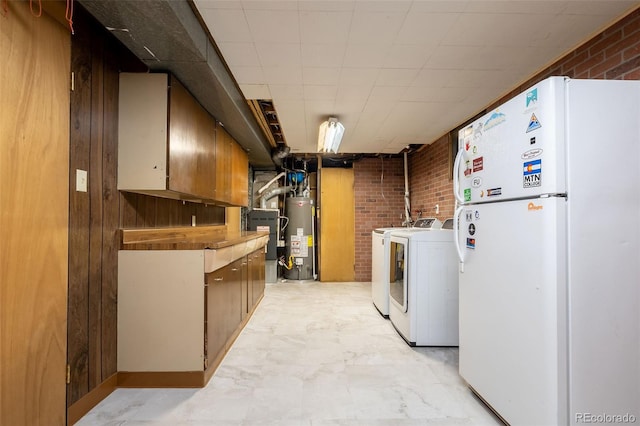 washroom featuring cabinets, wood walls, brick wall, gas water heater, and washer and clothes dryer